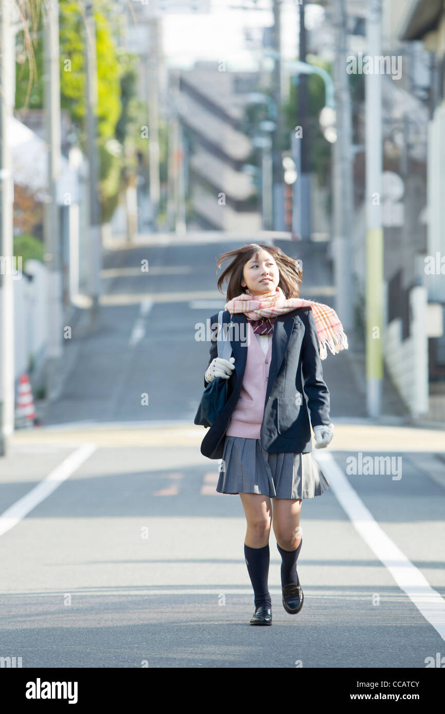 High school girl waling down the street Stock Photo
