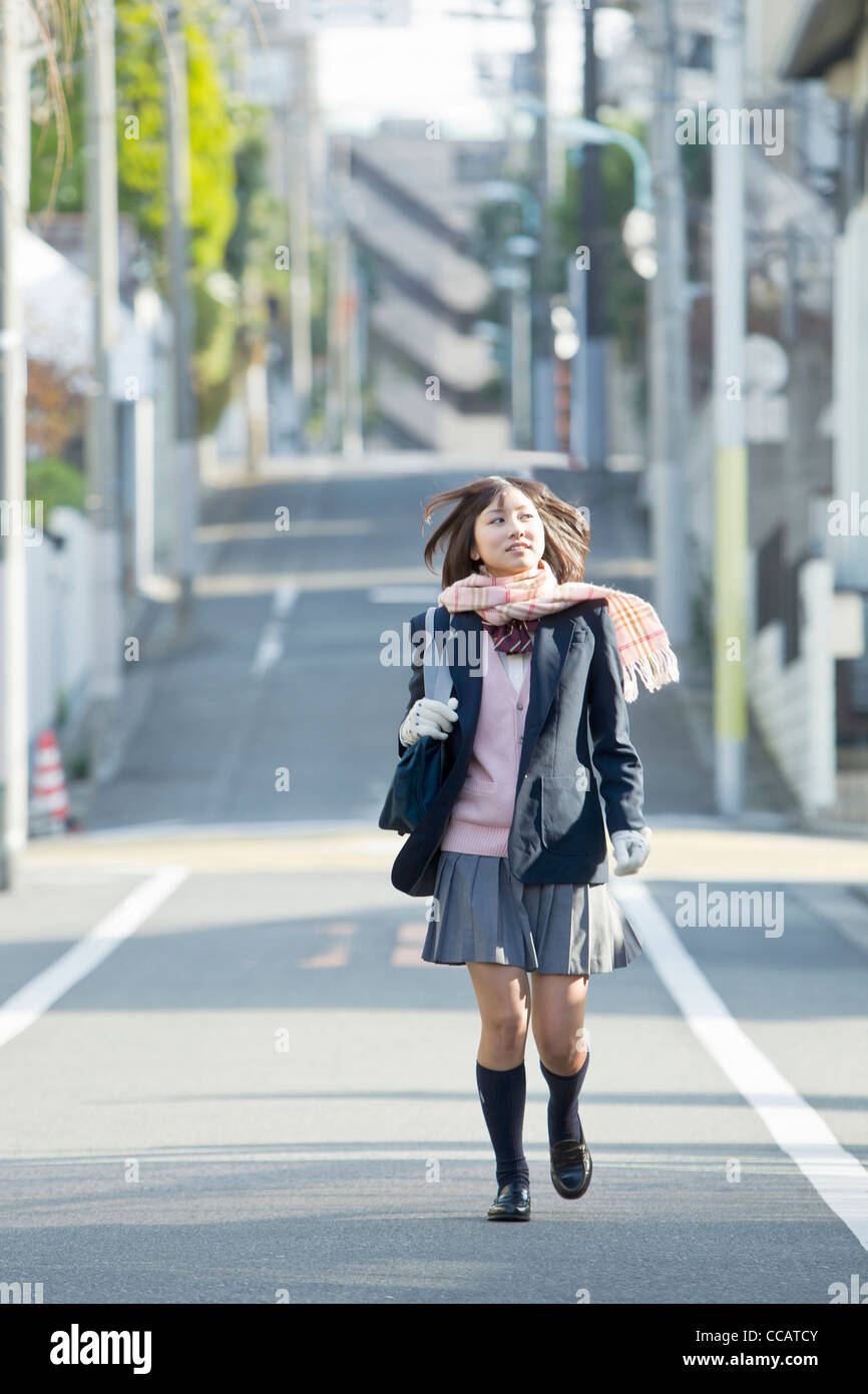 High school girl waling down the street Stock Photo - Alamy