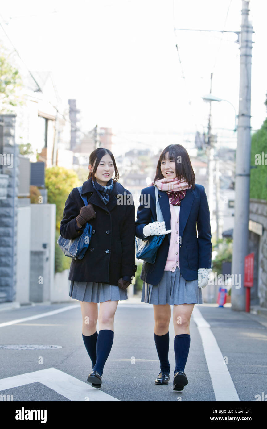 Two high school girls walking in the street Stock Photo