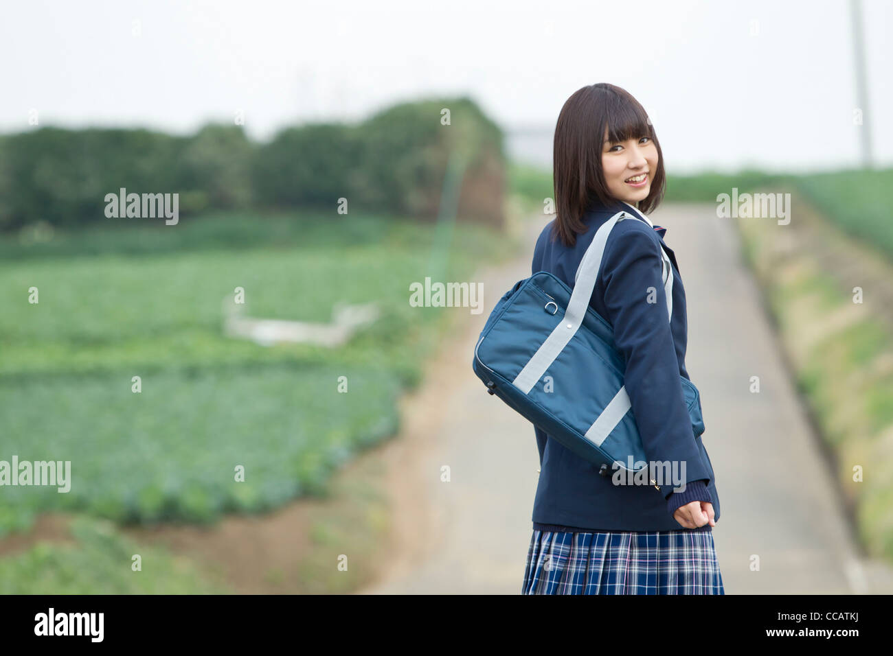 High school girl standing on rural road Stock Photo