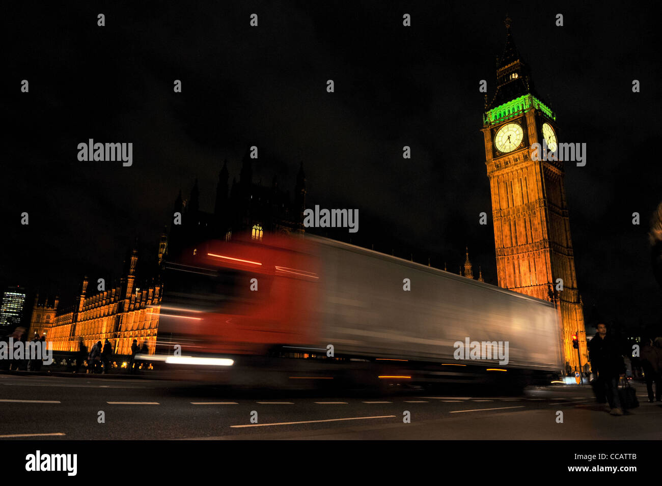 London Houses of Parliament and big Ben at night from Waterloo bridge with a passing lorry blurred in foreground Stock Photo