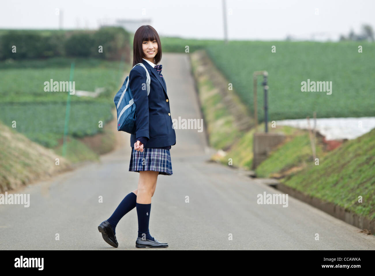 Female High School Student Standing on Rural Road Stock Photo - Alamy