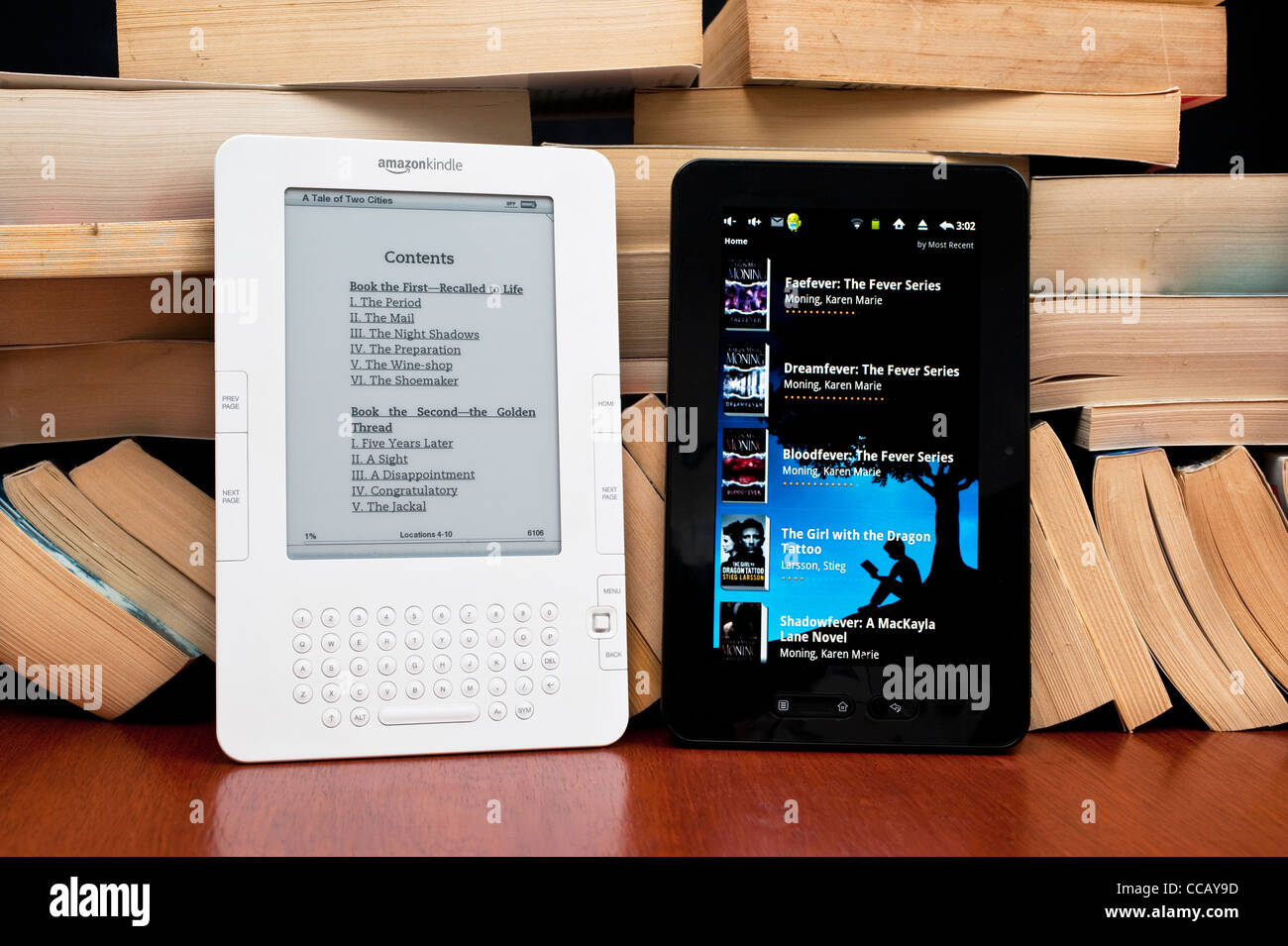 A Kindle and an Android Tablet ereaders side by side with a pile of