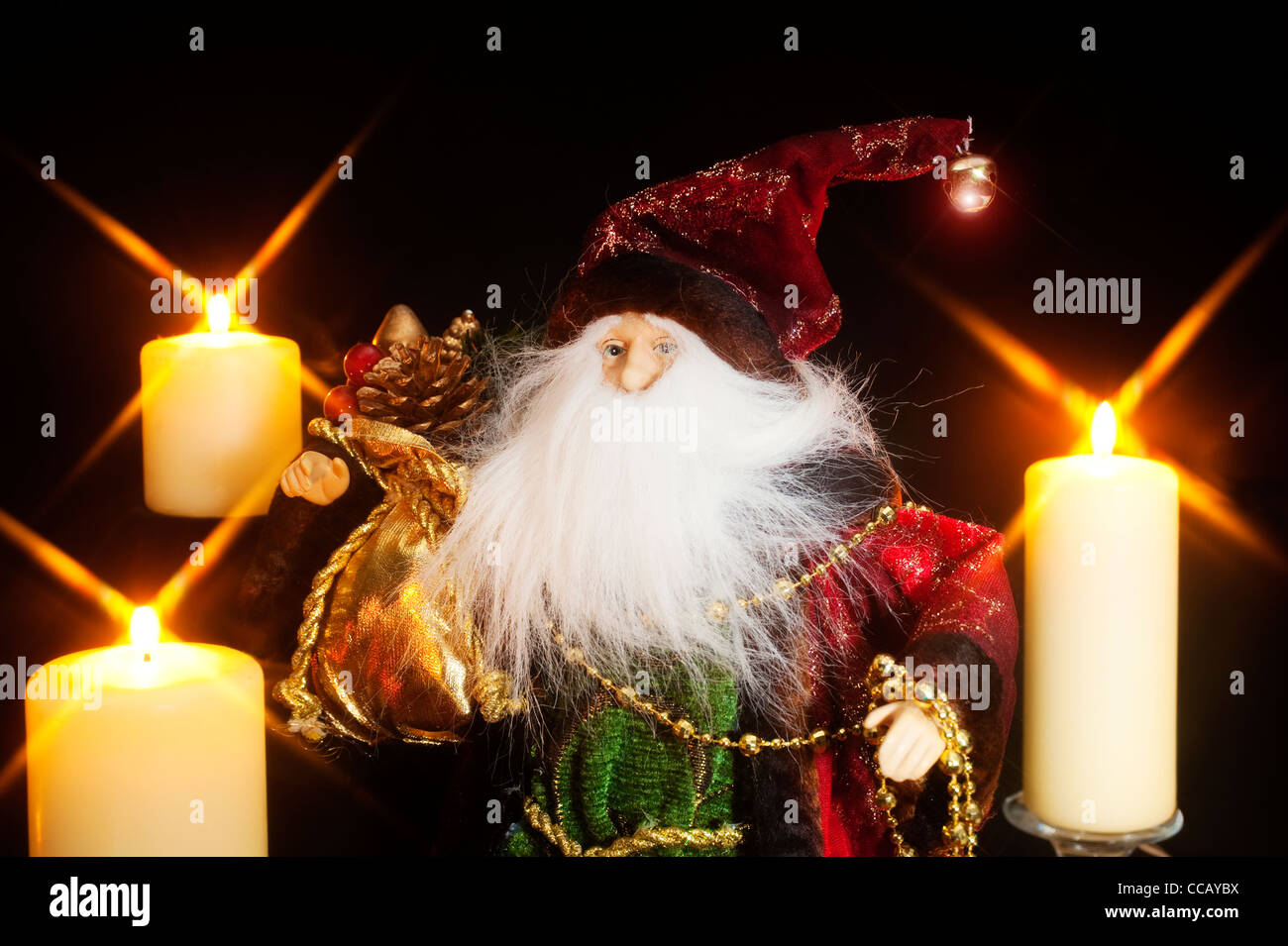 A Santa Claus figure with a big white beard with candles Stock Photo