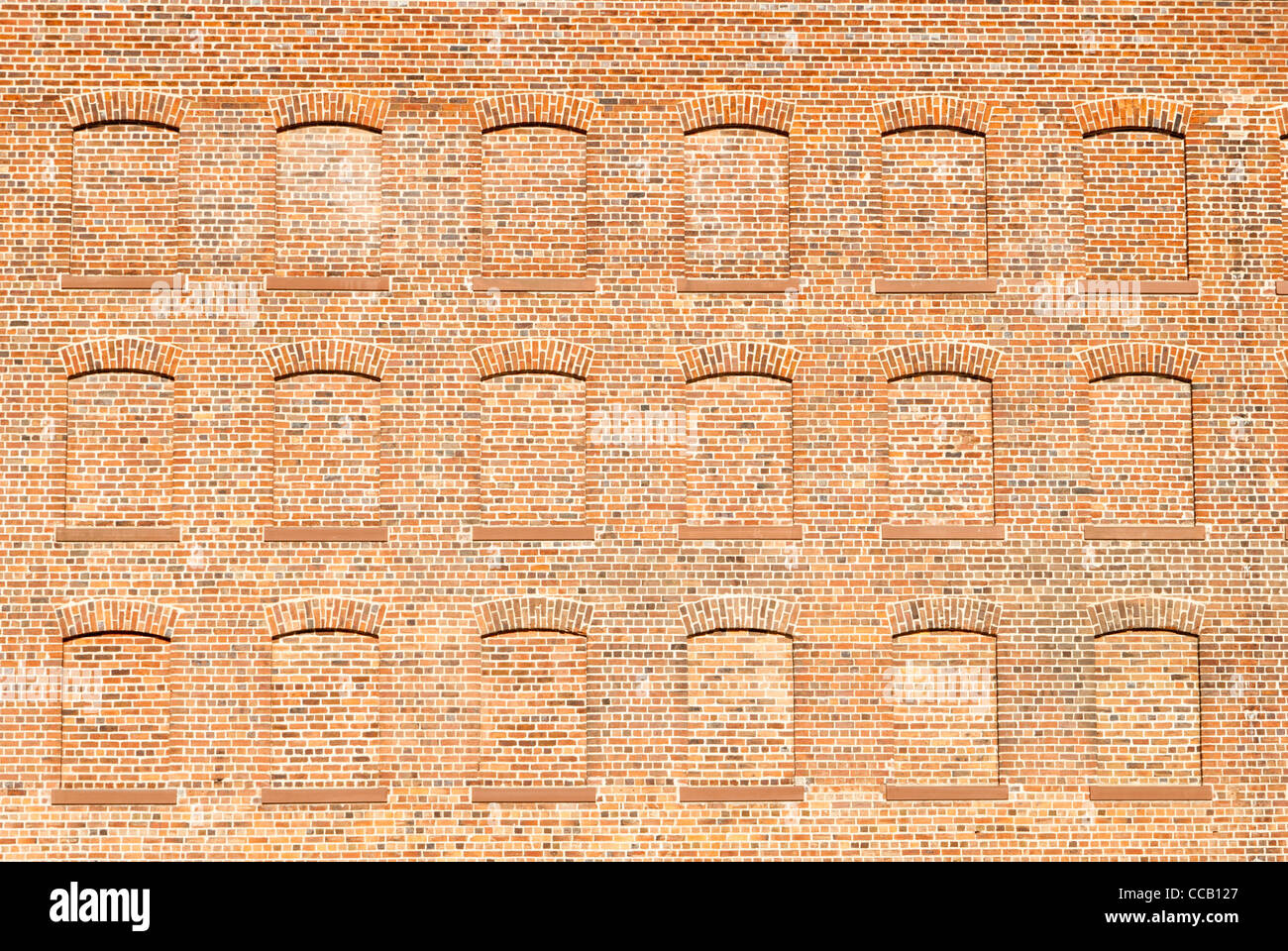 Decorative traditional red brick wall with bricked up windows Stock