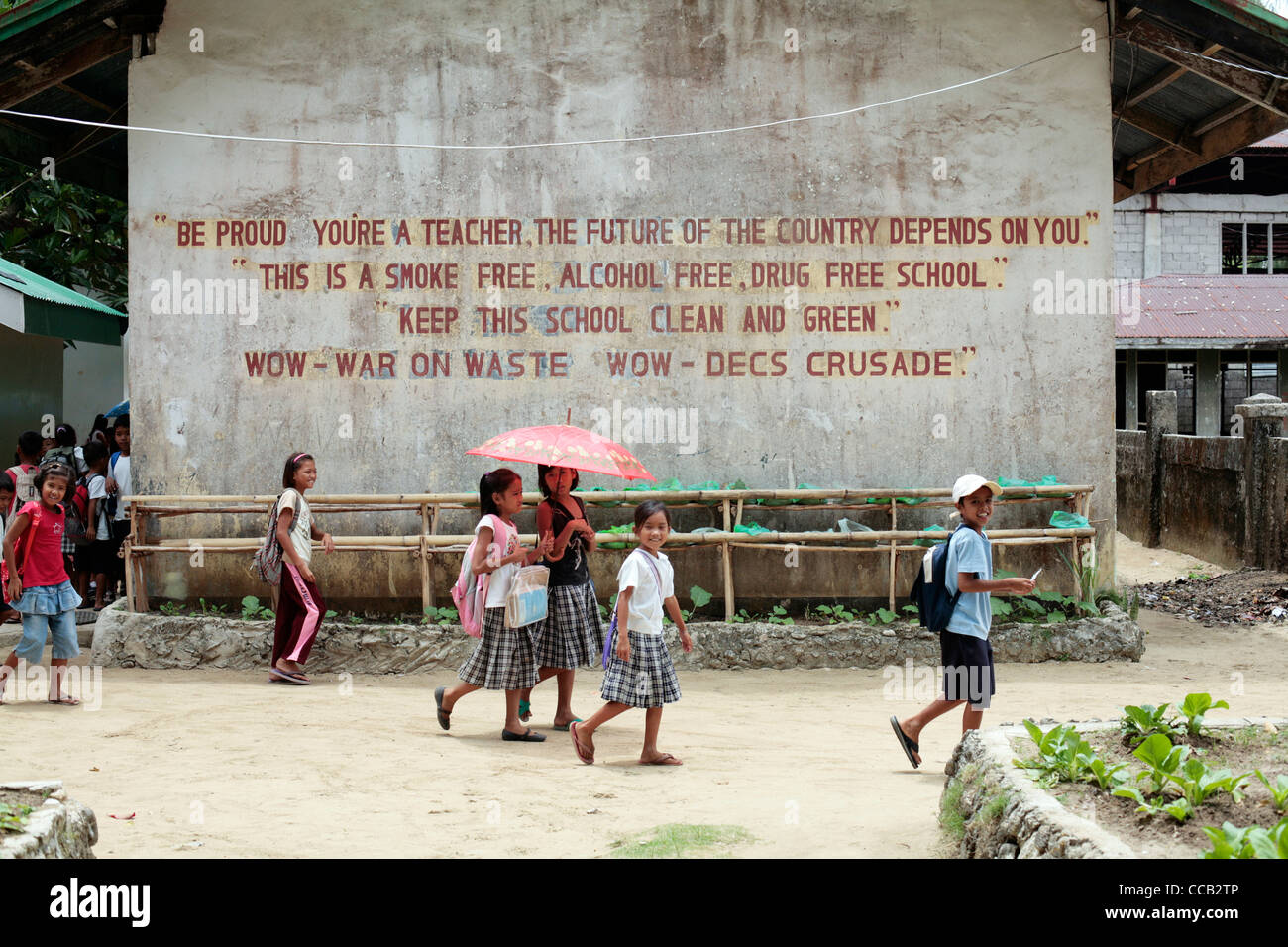 Local school children and slogan on a school wall on the island of Siargao, Philippines. Stock Photo