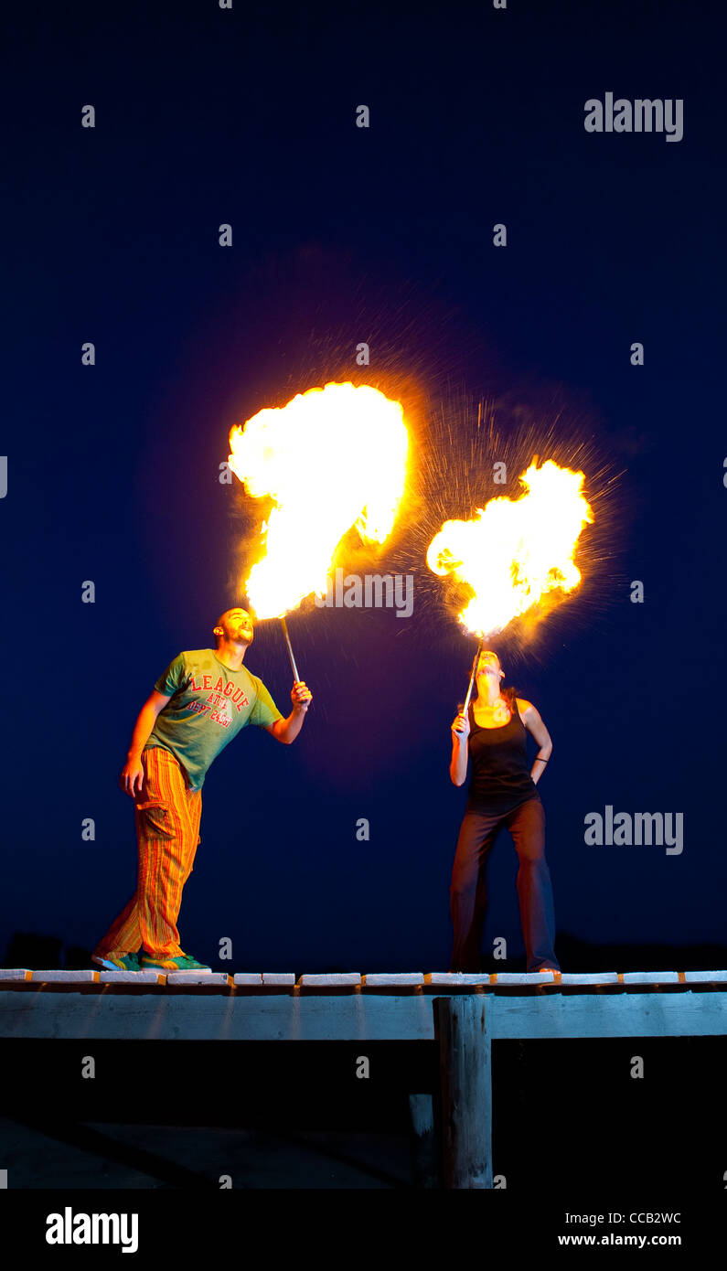 Fire eaters performing on the beach pier, Alcudia at dusk, Majorca. Stock Photo