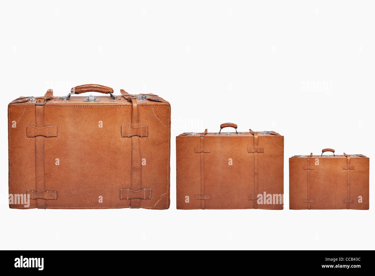 Detailansicht dreier stehender, alten braunen Lederkoffer | Detail photo of three old brown leather suitcases, upright Stock Photo