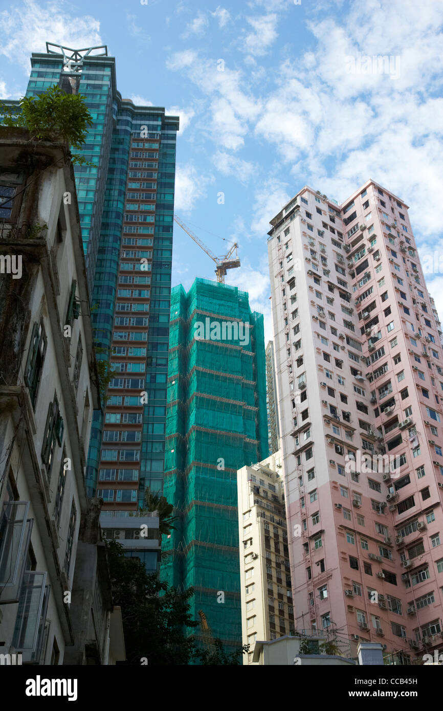 building a new skyscraper between high rise hi density housing tower apartment block skyscrapers hong kong hksar china asia Stock Photo
