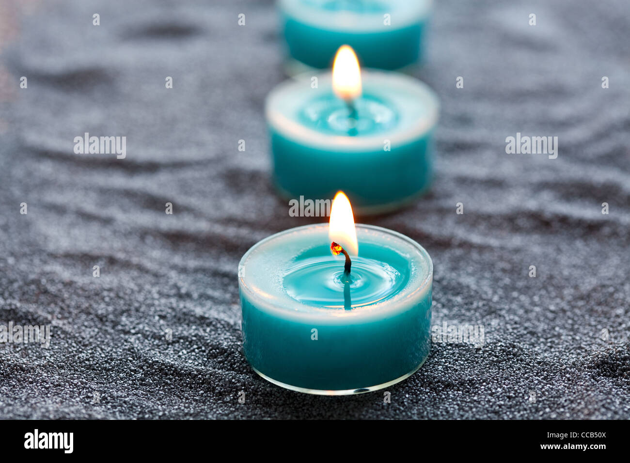 Close-up of blue candles on silver sand Stock Photo