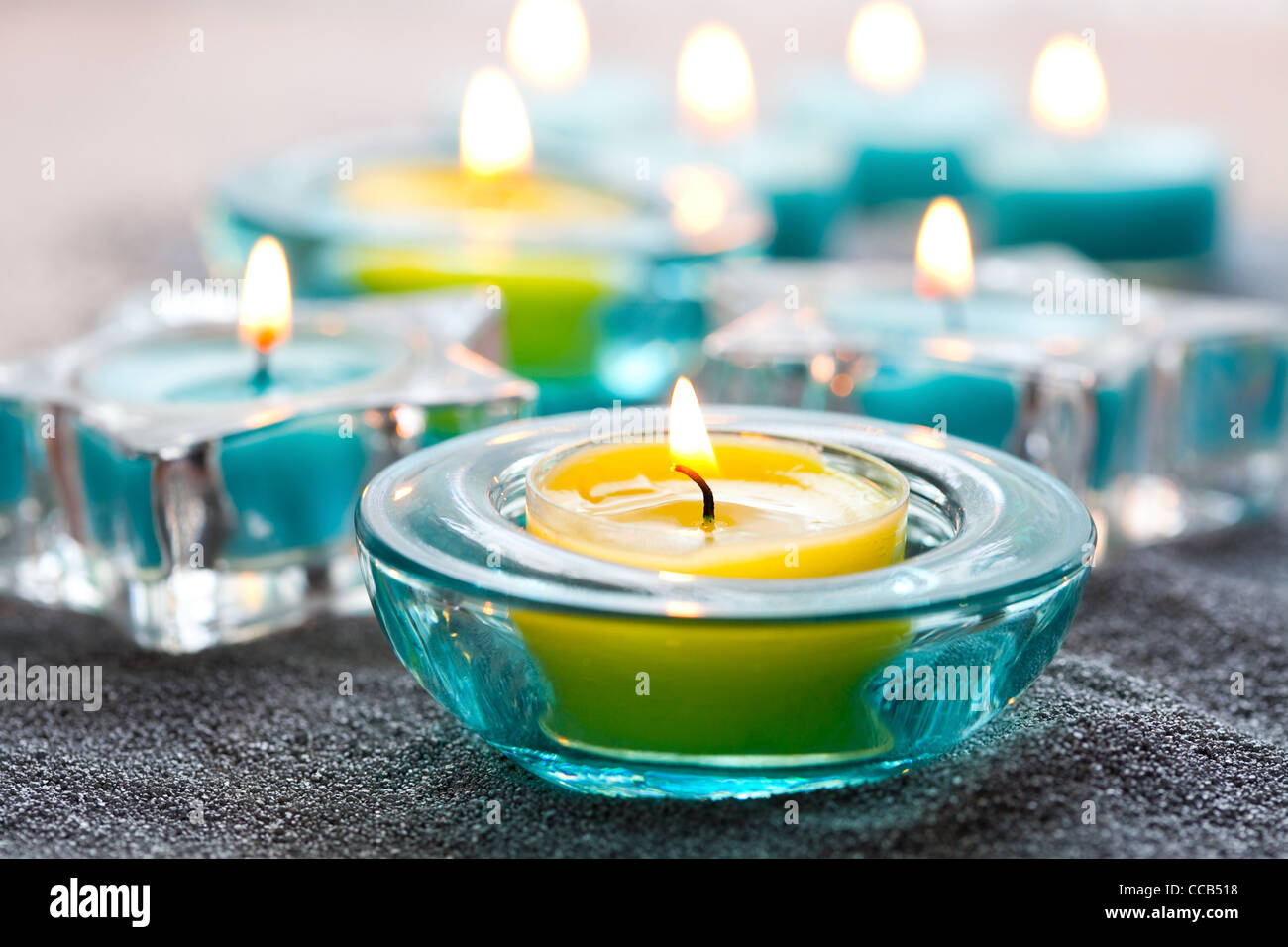Close-up of blue and yellow Christmas candles on silver sand Stock Photo