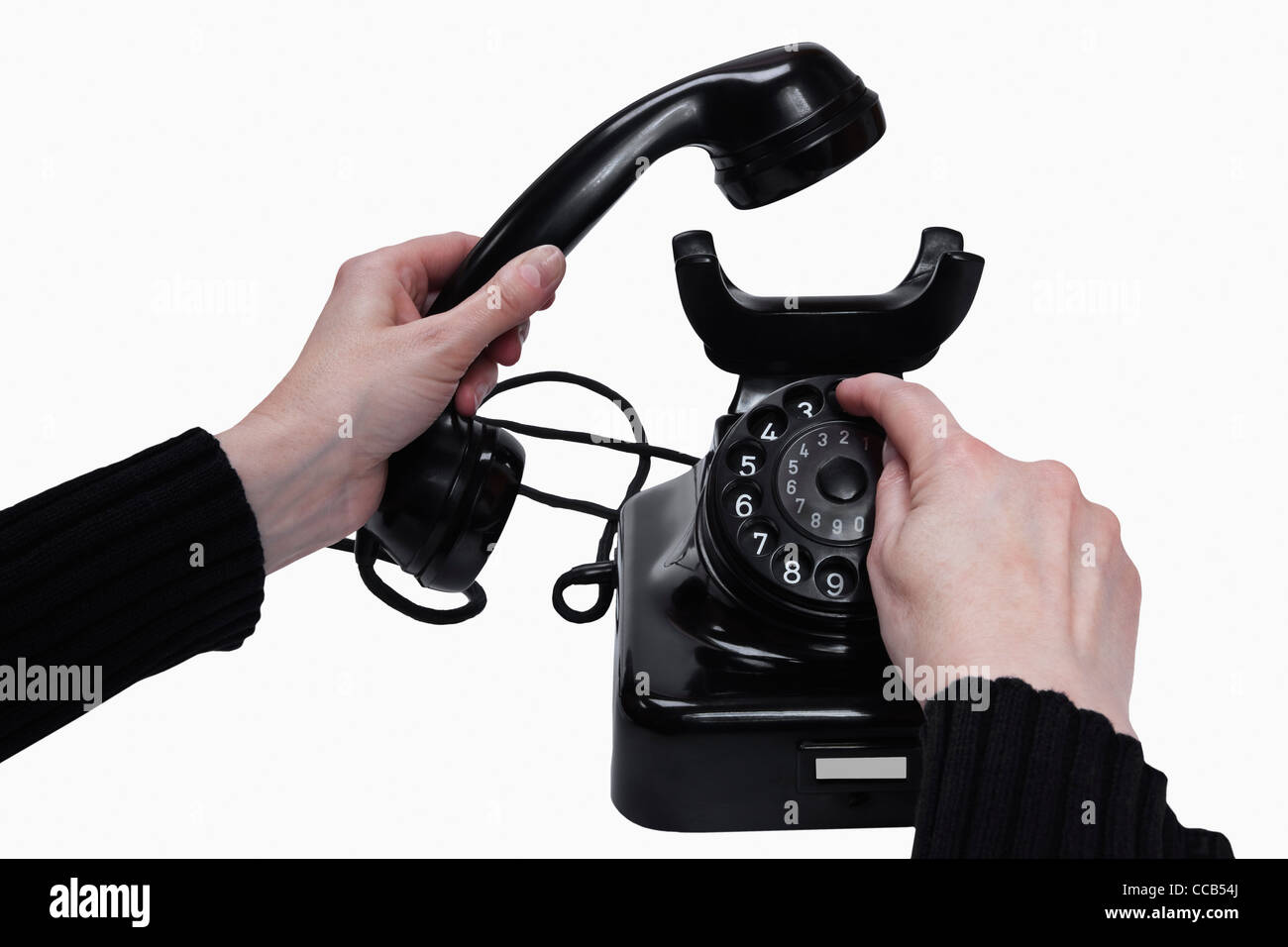 Detail photo of a old black telephone, the telephone receiver is hand