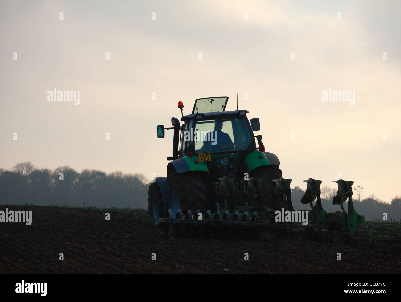 A tractor driver working on the land in winter in North Norfolk Stock