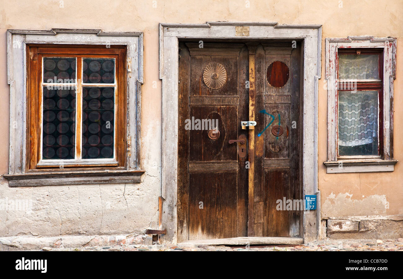 Old wooden front door and windows of dilapidated house in the UNESCO German town of Quedlinburg in Saxony Anhalt, Germany Stock Photo