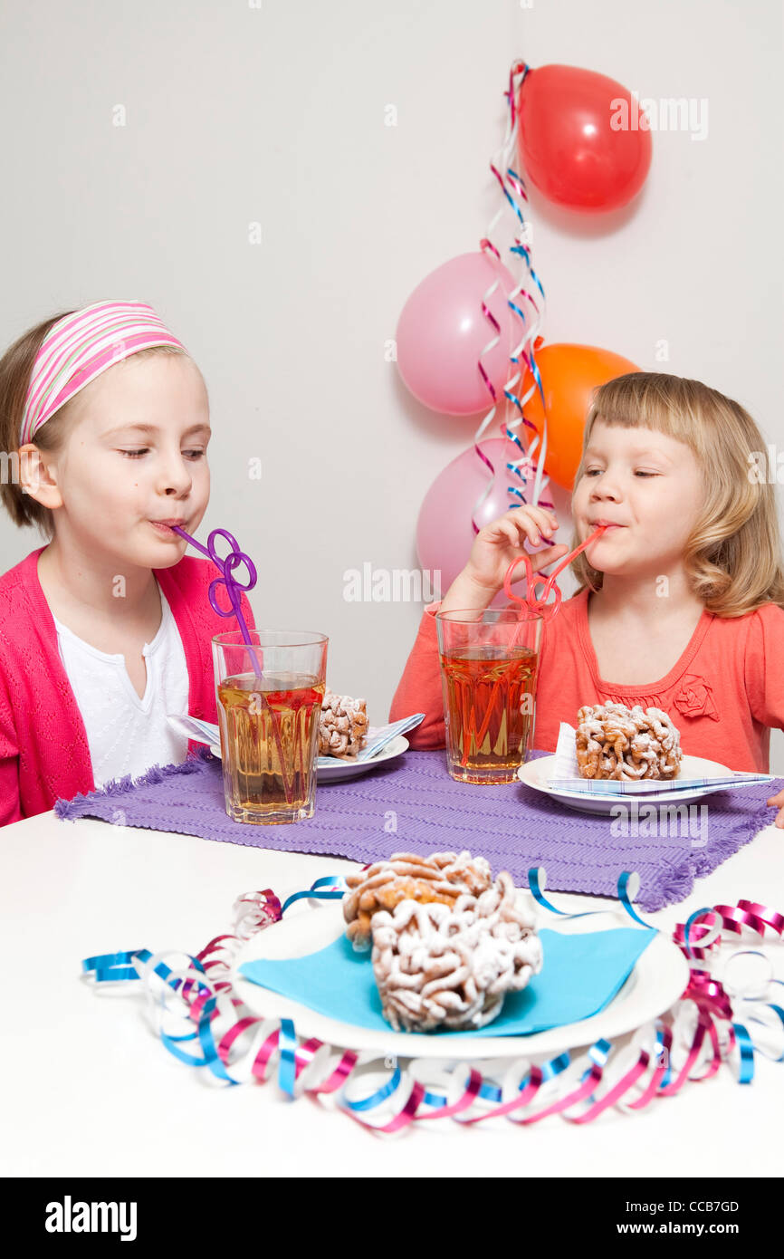 Girls having a traditional finnish May Day celebration, eating funnel cake, tippaleipa and drinking mead, sima Stock Photo