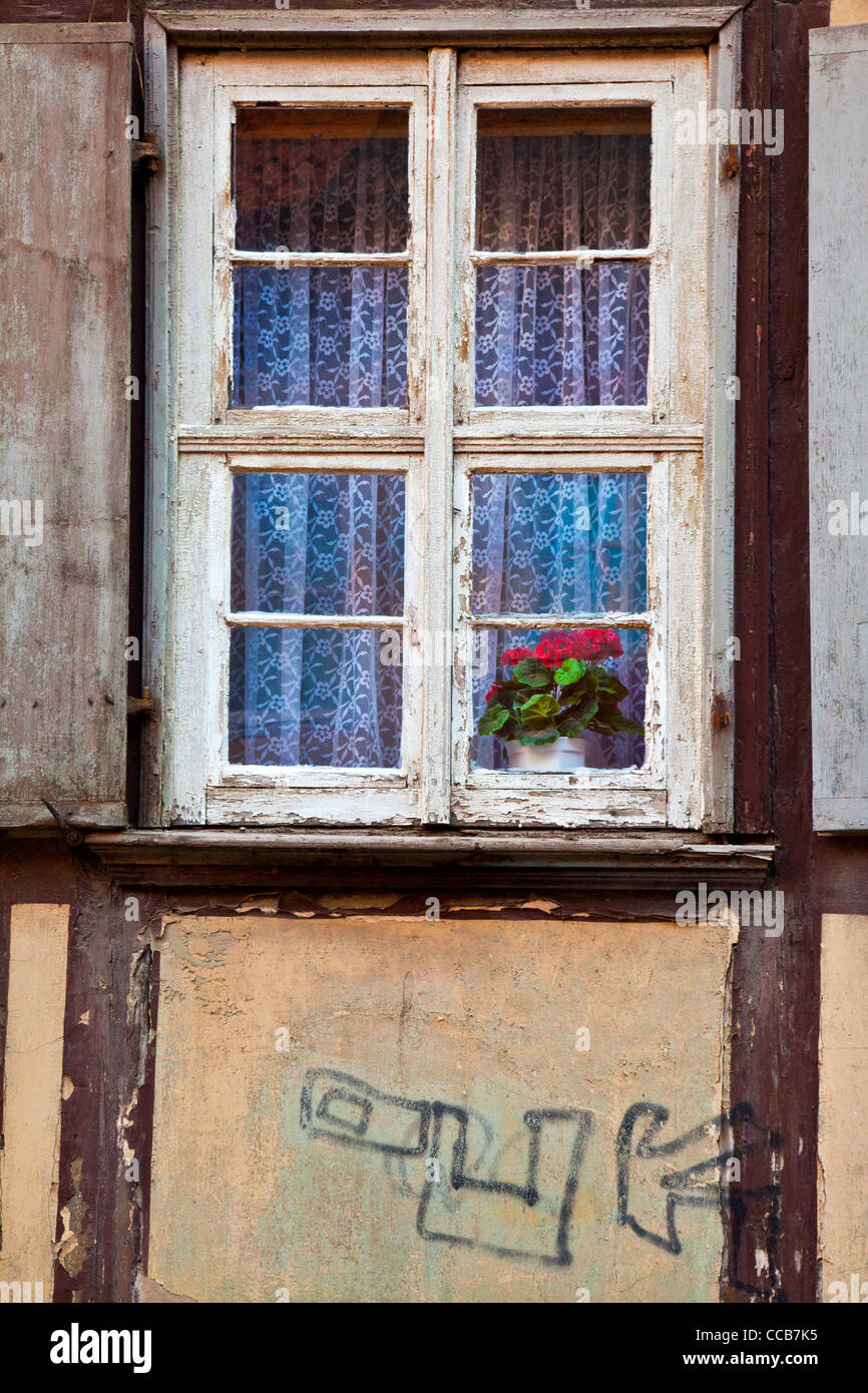 An old window on a dilapidated house facade in the UNESCO German town of Quedlinburg in Saxony Anhalt, Germany Stock Photo