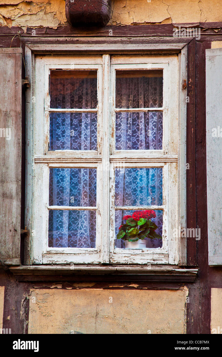 An old wooden window on a dilapidated house facade in the UNESCO German town of Quedlinburg in Saxony Anhalt, Germany Stock Photo