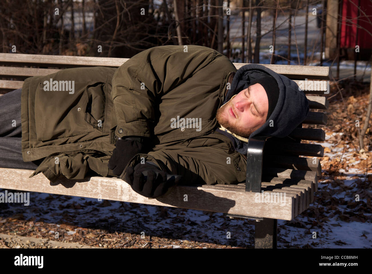 Homeless man sleeping on park bench on cold winter day Stock Photo - Alamy