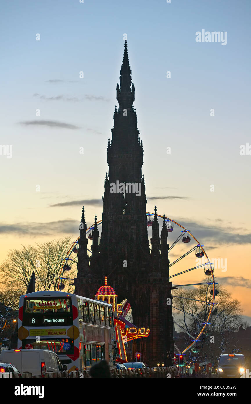 Scott Monument flanked by big Christmas Ferris Wheel in Princes Street Gardens, Edinburgh, Scotland, UK, at dusk Stock Photo