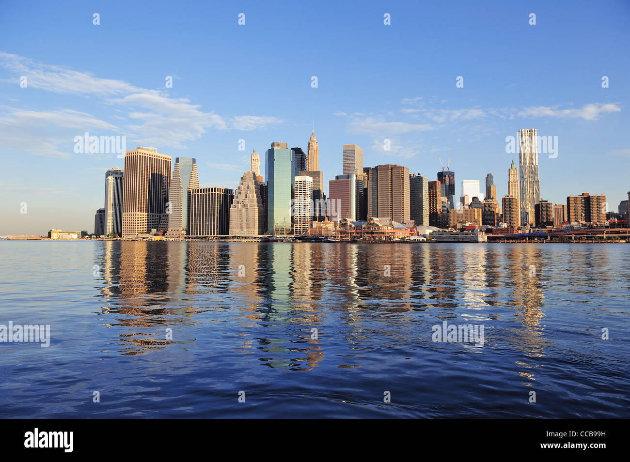 Lower Manhattan skyline panorama over East River with reflection and ...