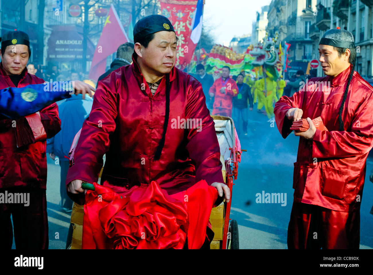 Paris, France, Chinese men in Traditional Dress, Parading in Chinese new year Carnival in Street in the Marais District, Distributing Fireworks in Richshaw Stock Photo