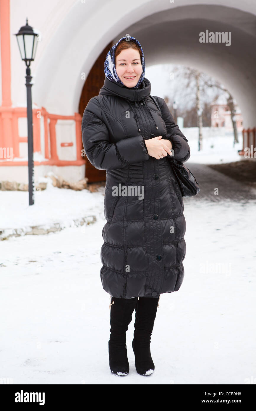 Russian woman in winter clothes against Orthodox monastery