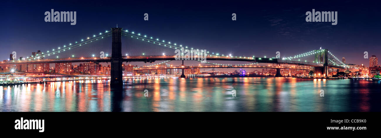 Brooklyn Bridge panorama over East River at night in New York City ...