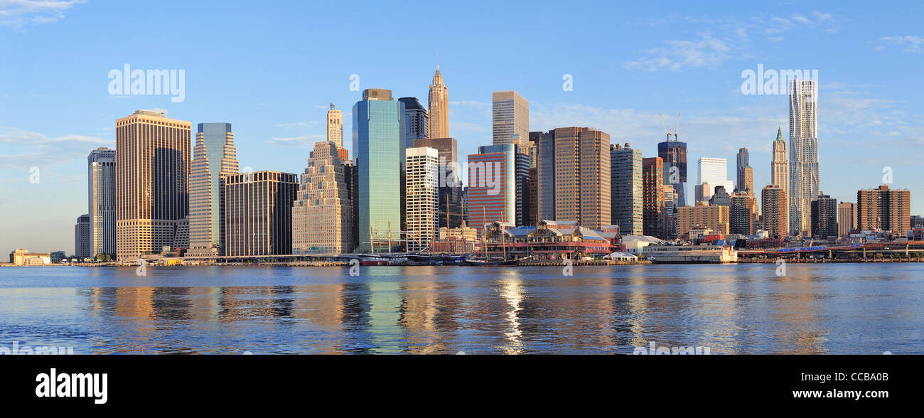 Lower Manhattan skyline panorama over East River with reflection and ...