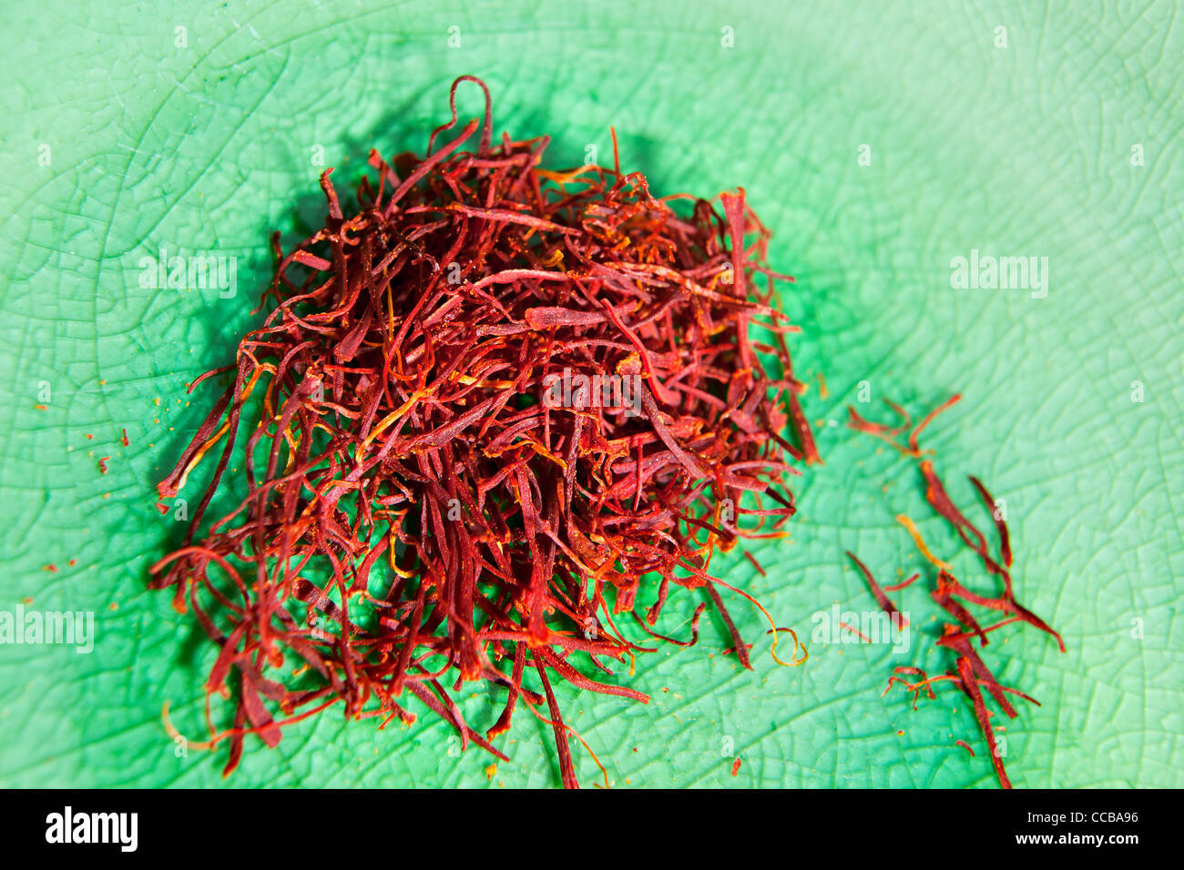Dried saffron spice in a green enamel glass dish or bowl for cooking Stock Photo Alamy