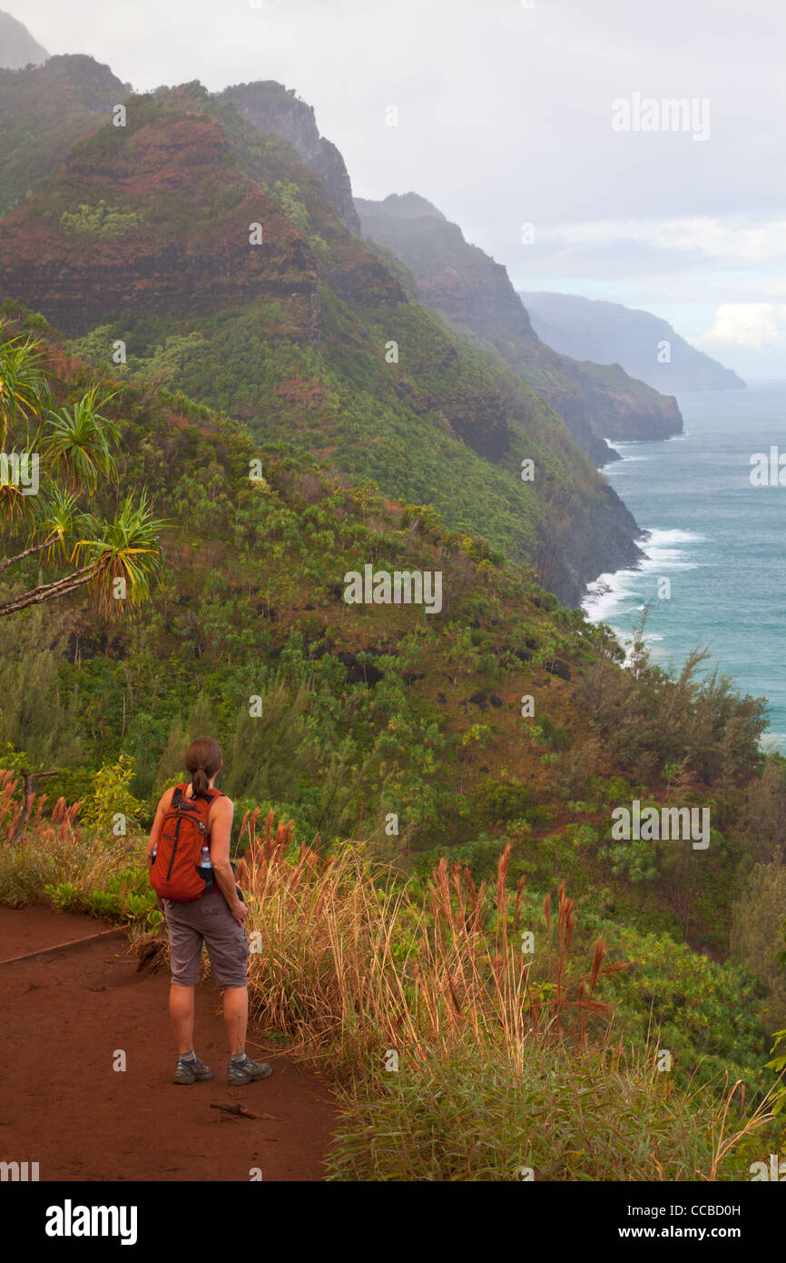 A hiker on the Kalalau Trail, Na Pali Coast, Kauai, Hawaii. (model released) Stock Photo