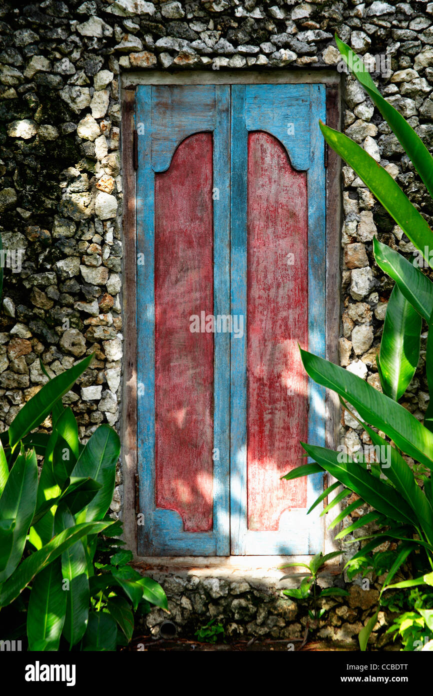 carved wooden doors in stone wall Stock Photo