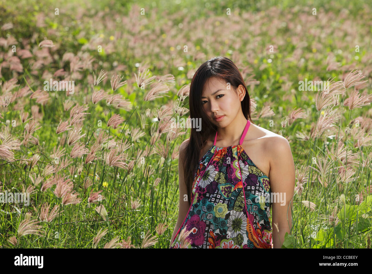 young woman standing in field of grass Stock Photo - Alamy