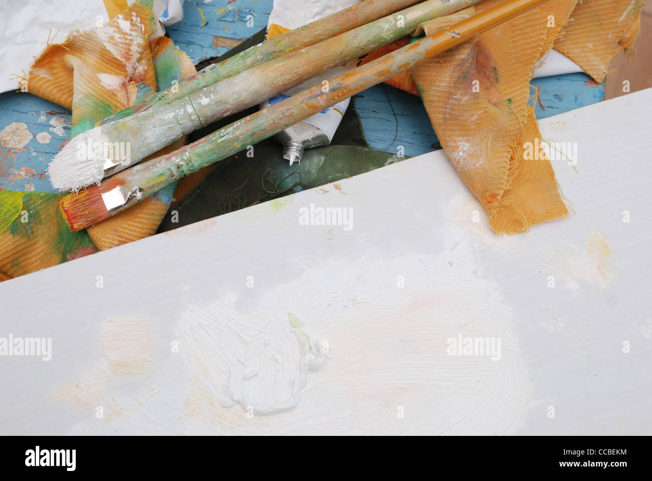 artist's stained palette, three brushes and paint tubes Stock Photo