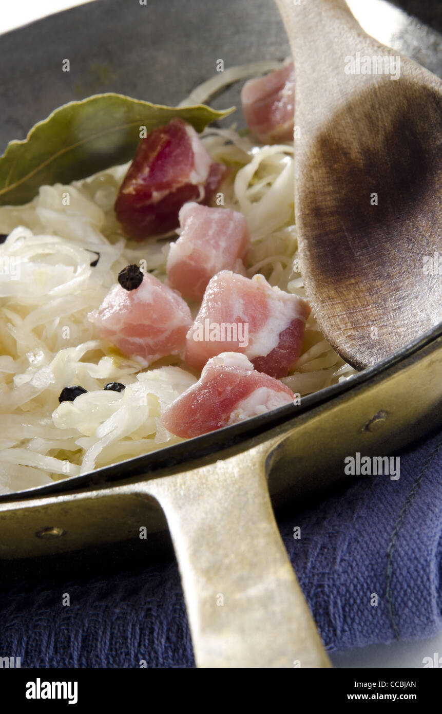 Sauerkraut with diced bacon and bay leaf in a pan Stock Photo