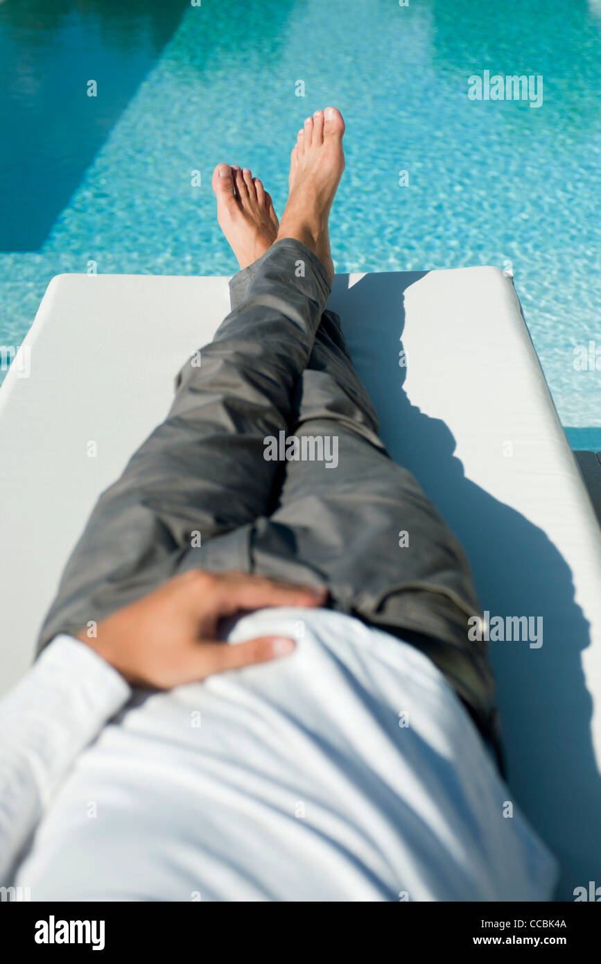 Man relaxing on lounge chair beside pool Stock Photo Alamy