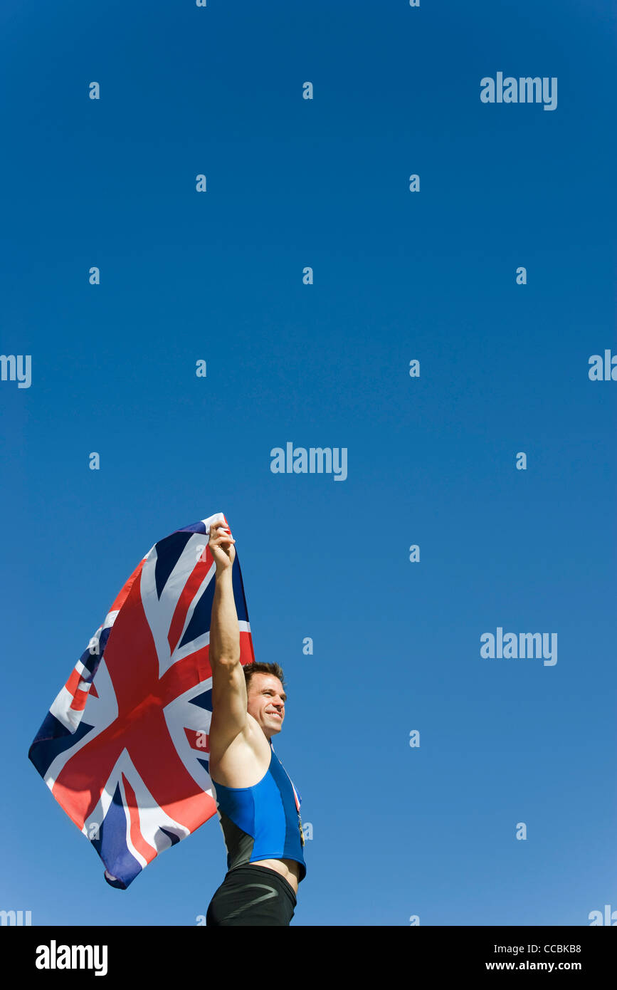 Male athlete holding up British flag Stock Photo