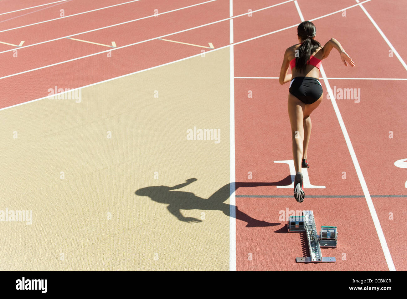Female runner on track, rear view Stock Photo