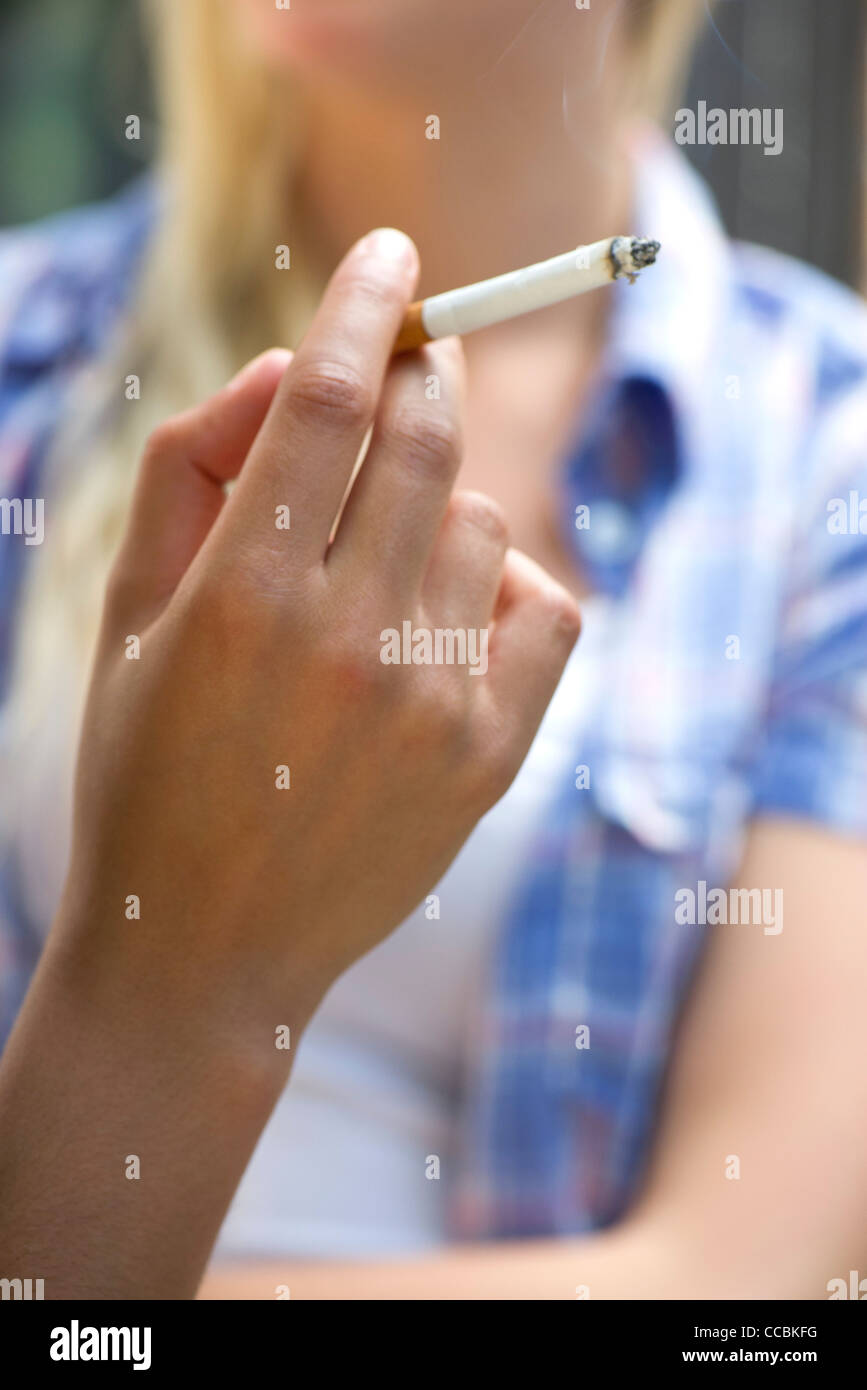 Woman's hand holding lit cigarette Stock Photo
