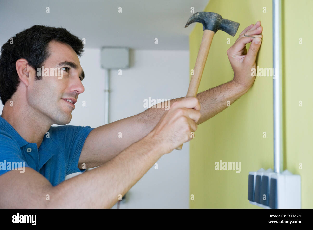 Man hammering nail into wall Stock Photo Alamy