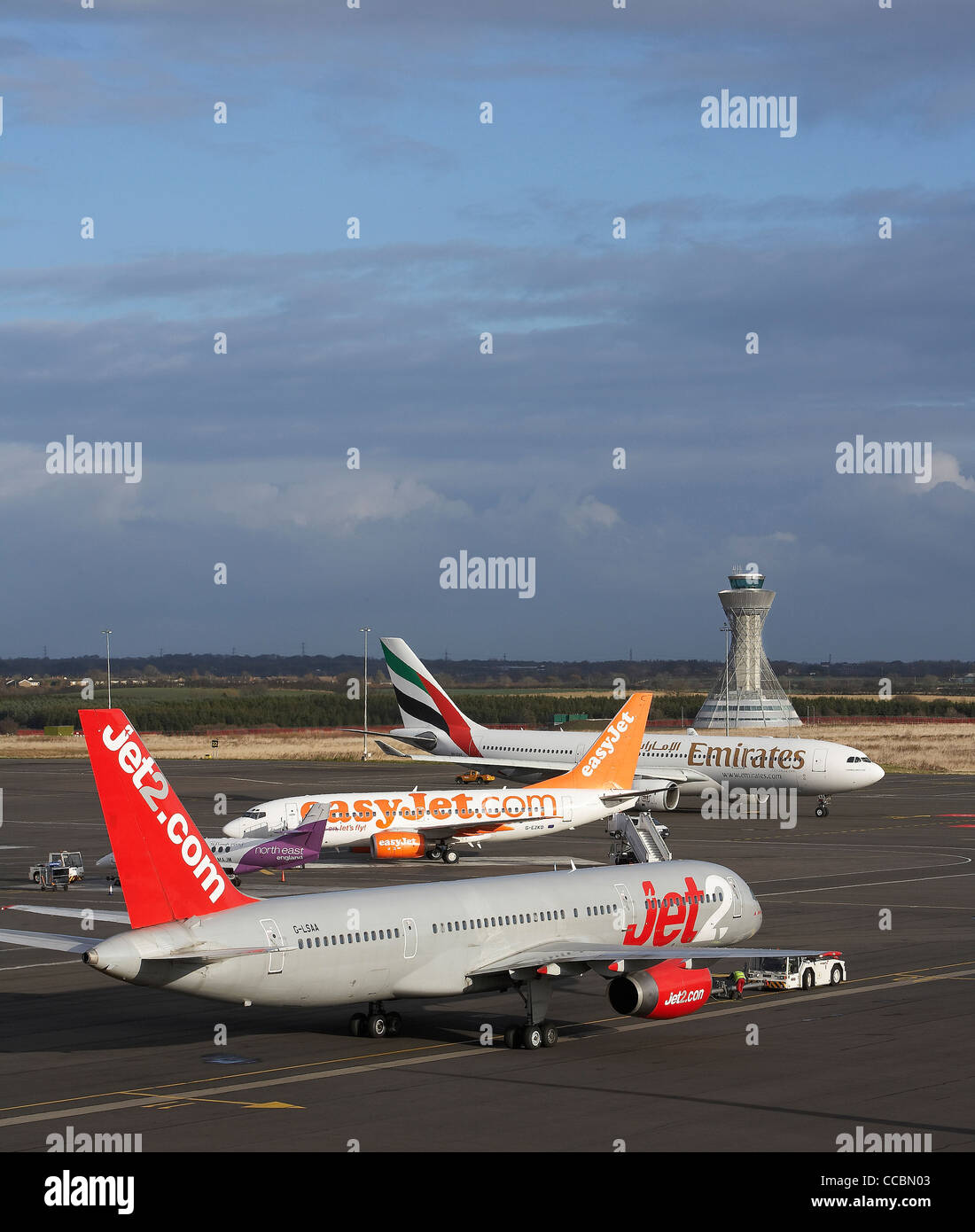 NEWCASTLE AIRPORT CONTROL TOWER TOWER WITH PLANES LINED UP IN FOREGROUND Stock Photo