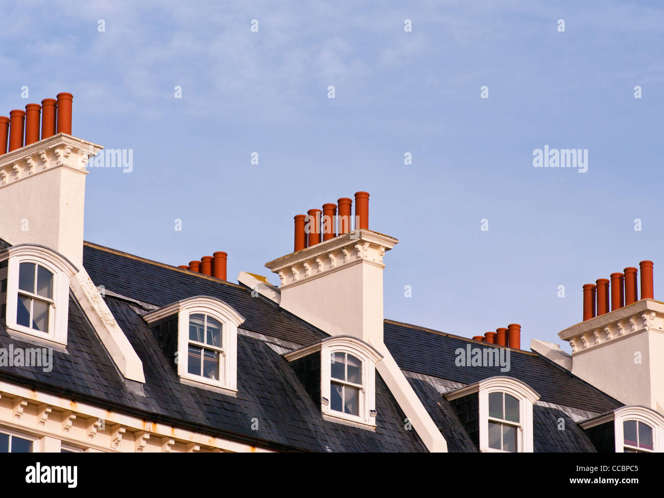 Dormer Windows On Slate Tiled Tiles Roofs Rooftops With Red Terracotta Chimneys On Stacks Stock Photo