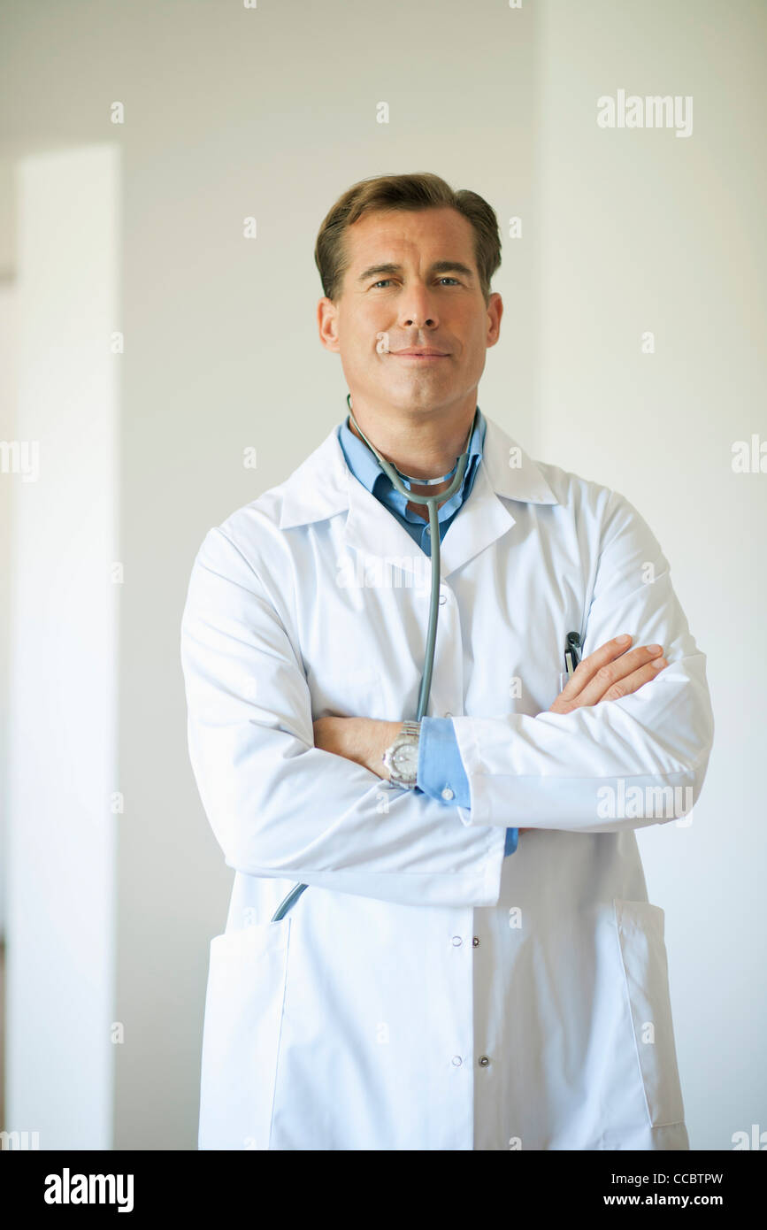 Doctor standing with arms folded, portrait Stock Photo