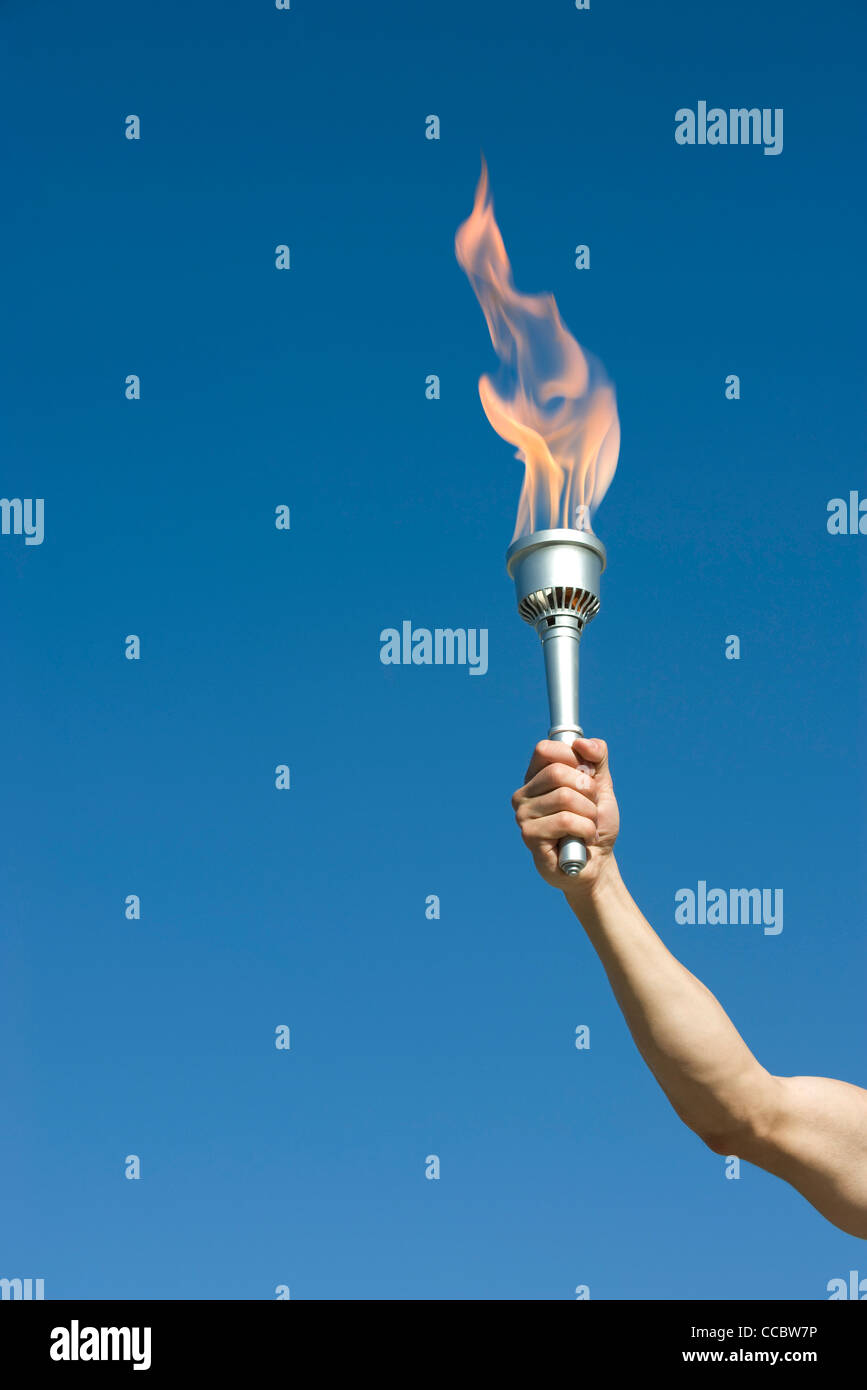 Man's arm holding up torch Stock Photo