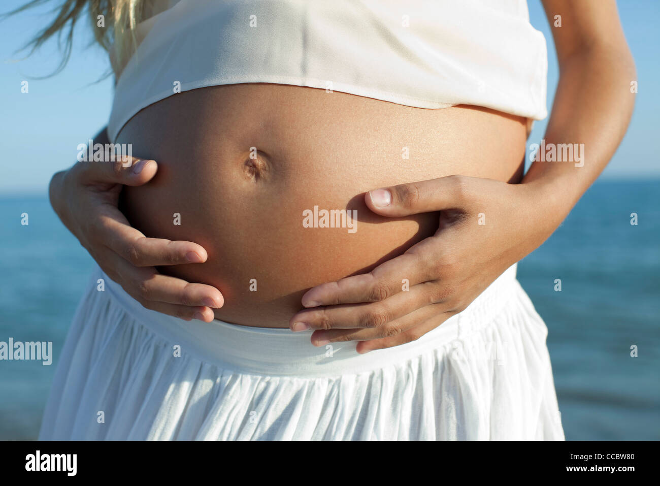 Woman's hands on pregnant belly, cropped Stock Photo Alamy