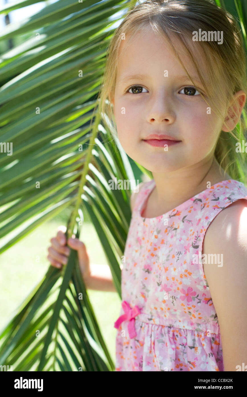 Little girl holding palm leaf, portrait Stock Photo