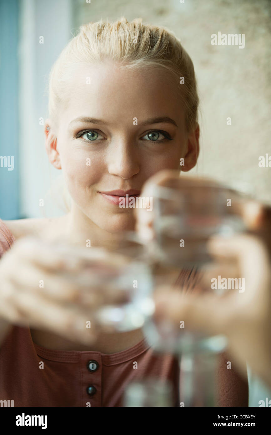Young blond woman raising glass Stock Photo