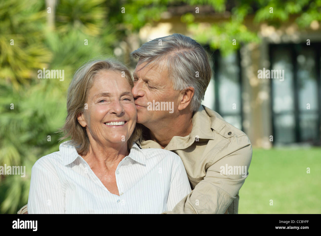 Senior man kissing his wife on the cheek Stock Photo