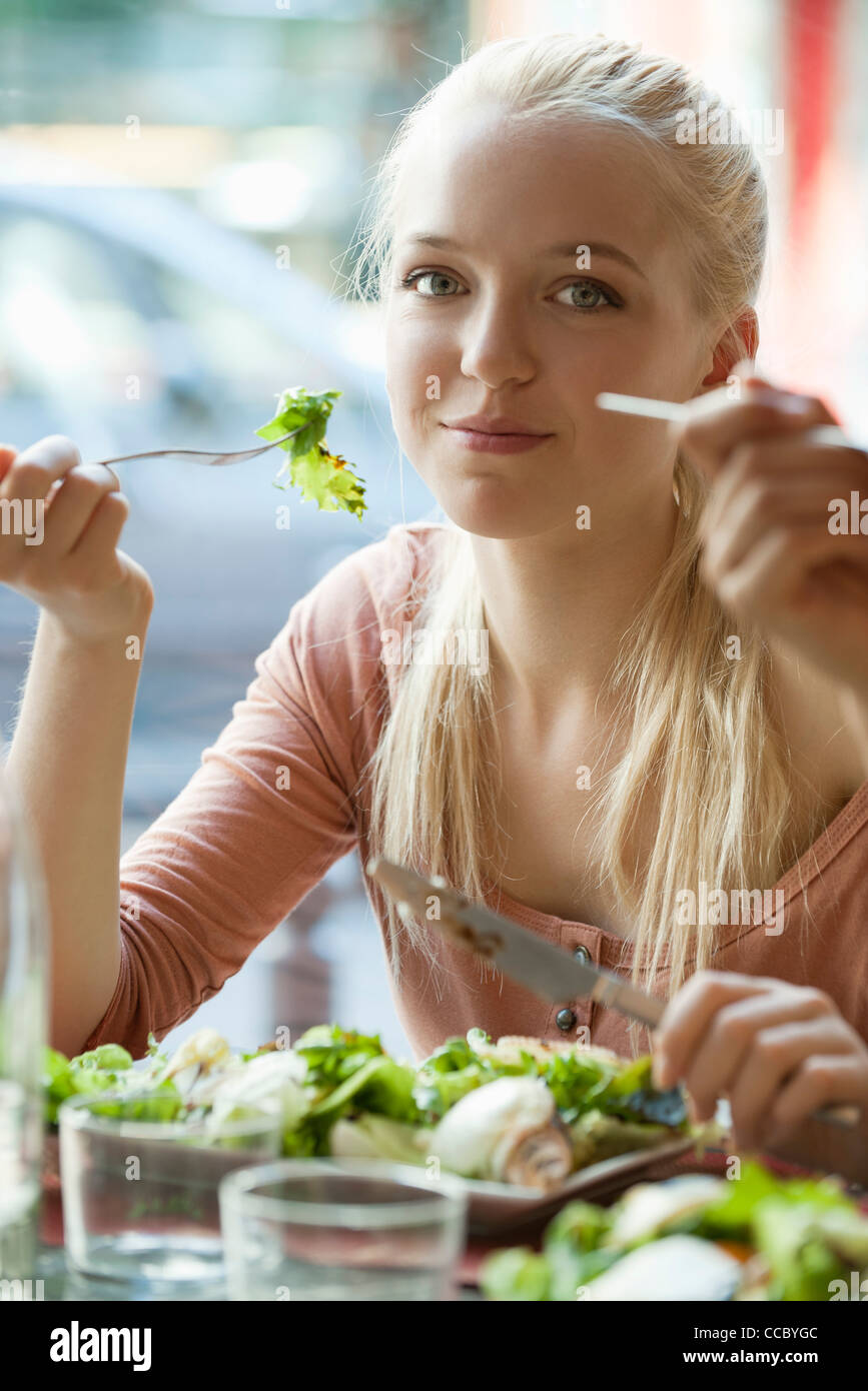 Young blond woman eating salad Stock Photo