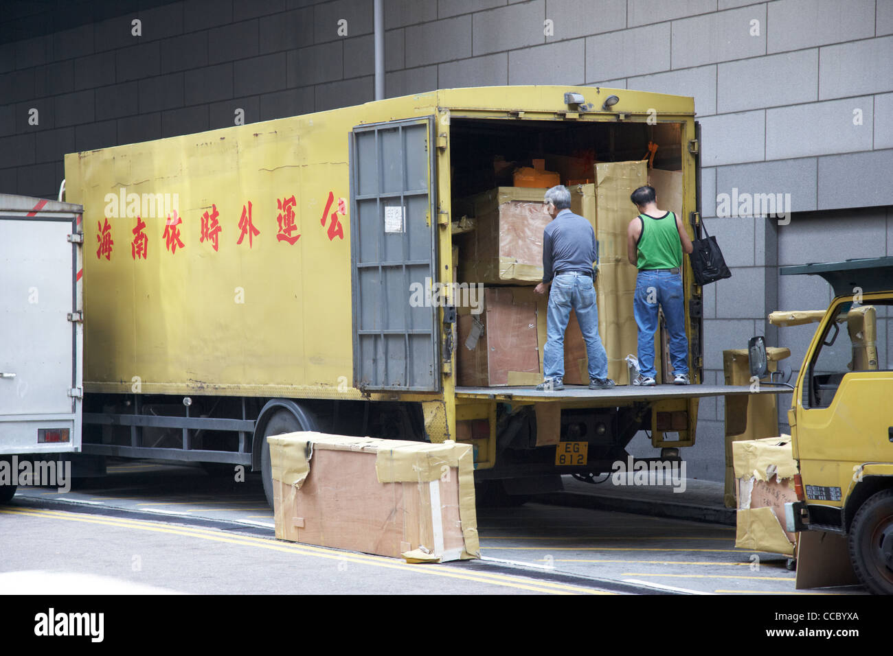 men loading unloading packing crates from the back of a tail lift van lorry hong kong hksar china asia Stock Photo