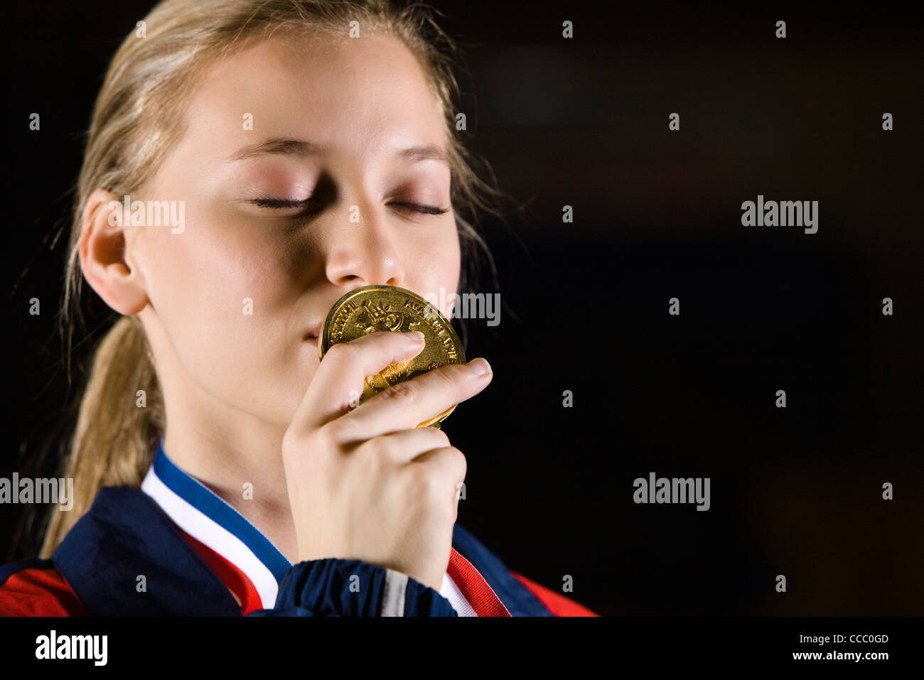 Female athlete kissing gold medal, portrait Stock Photo